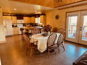 Dining room featuring light tile patterned floors, a wealth of natural light, and wooden ceiling