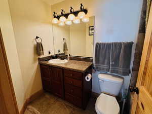 Ensuite bathroom featuring vanity, toilet, and tile patterned flooring