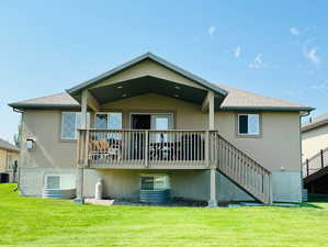 Back of house featuring a wooden deck, central air condition unit, and a lawn