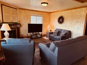 Living room with a tiled fireplace and ornamental molding