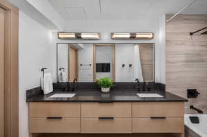 Bathroom featuring tub / shower combination and dual bowl vanity