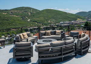 View of patio / terrace featuring a balcony, an outdoor living space with a fire pit, and a mountain views