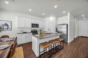 Kitchen featuring white cabinetry, a kitchen island with sink, sink, and stainless steel appliances