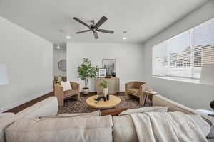 Living room with ceiling fan, hardwood / wood-style floors, and a textured ceiling