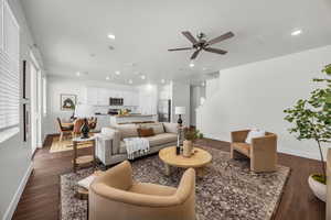 Living room with a textured ceiling, dark hardwood / wood-style floors, and ceiling fan