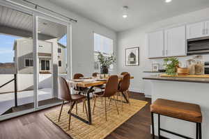 Dining space with dark wood-type flooring