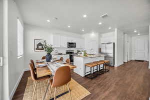 Dining area with a textured ceiling, dark hardwood / wood-style flooring, and sink