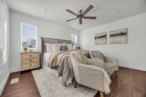 Bedroom with multiple windows, dark hardwood / wood-style floors, and ceiling fan