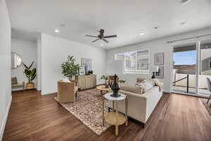 Living room with dark hardwood / wood-style flooring, a healthy amount of sunlight, and a textured ceiling