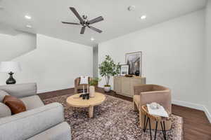 Living room featuring dark hardwood / wood-style floors, ceiling fan, and a textured ceiling