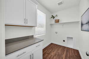 Washroom featuring cabinets, washer hookup, dark hardwood / wood-style flooring, and hookup for an electric dryer