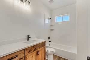 Full bathroom with vanity, toilet, wood-type flooring, and shower / washtub combination