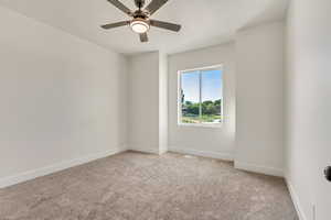 Carpeted empty room with ceiling fan