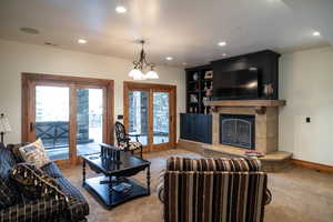 Living room with light carpet, a tile fireplace, and french doors