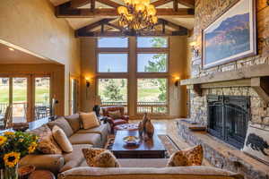 Living room featuring high vaulted ceiling, a fireplace, and plenty of natural light