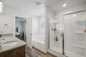 Bathroom featuring hardwood / wood-style floors, vanity, and independent shower and bath