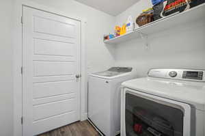 Clothes washing area with dark hardwood / wood-style floors and separate washer and dryer