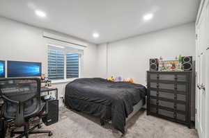 Bedroom featuring light carpet