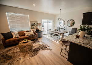 Living room featuring light hardwood / wood-style floors and a notable chandelier