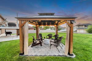 Patio terrace at dusk with a gazebo and a lawn