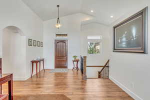 Entrance foyer with hardwood / wood-style flooring and vaulted ceiling