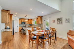 Dining space with light hardwood / wood-style flooring and sink