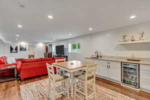 Dining area featuring sink, hardwood / wood-style flooring, and wine cooler