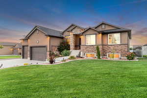 View of front of property with a garage and a lawn