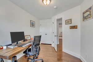 Home office with light hardwood / wood-style floors