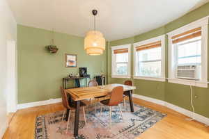 Dining area with cooling unit and hardwood flooring