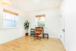 Home office featuring hardwood floors and a healthy amount of sunlight