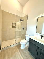 Bathroom featuring walk in shower, wood-type flooring, toilet, and vanity