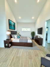 Bedroom featuring high vaulted ceiling and light wood-type flooring