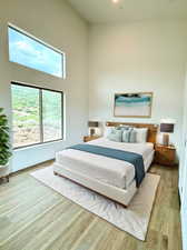 Bedroom with light hardwood / wood-style flooring and a high ceiling