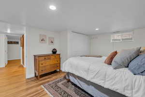 Bedroom with a closet and light hardwood / wood-style floors