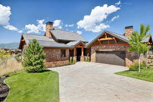 View of front of home featuring a front lawn and a garage