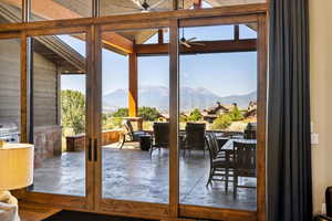 Entryway with lofted ceiling, a mountain view, and ceiling fan