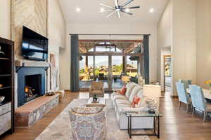 Living room with high vaulted ceiling and hardwood / wood-style flooring