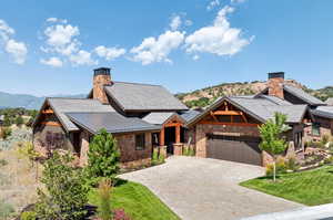 View of front of home featuring a front yard, a mountain view, and a garage