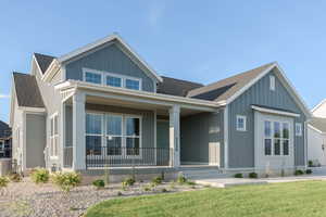 View of front of home featuring central AC unit, covered porch, and a front yard