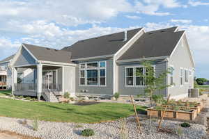 Back of house featuring central AC and a lawn