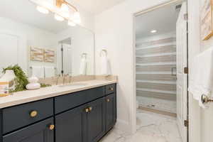 Bathroom featuring vanity, a shower with door, toilet, and tile patterned flooring