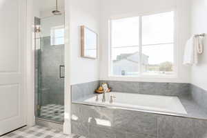 Bathroom featuring shower with separate bathtub and tile patterned flooring