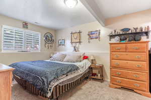 Bedroom featuring light carpet and a textured ceiling