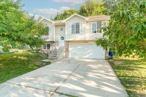 Split foyer home featuring a garage and a front yard