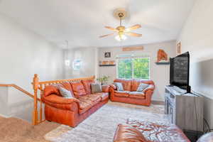 Carpeted living room featuring ceiling fan