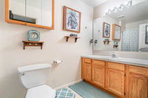 Bathroom with vanity, toilet, and a textured ceiling