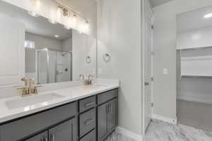 Bathroom featuring vanity and a shower with shower door