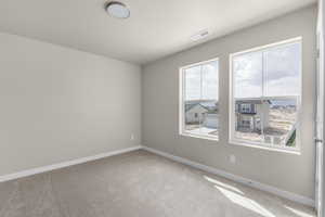 Empty room featuring plenty of natural light and light carpet