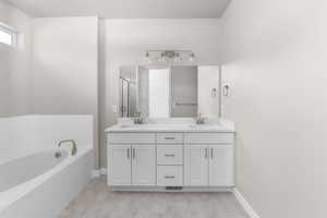 Bathroom featuring vanity and shower with separate bathtub